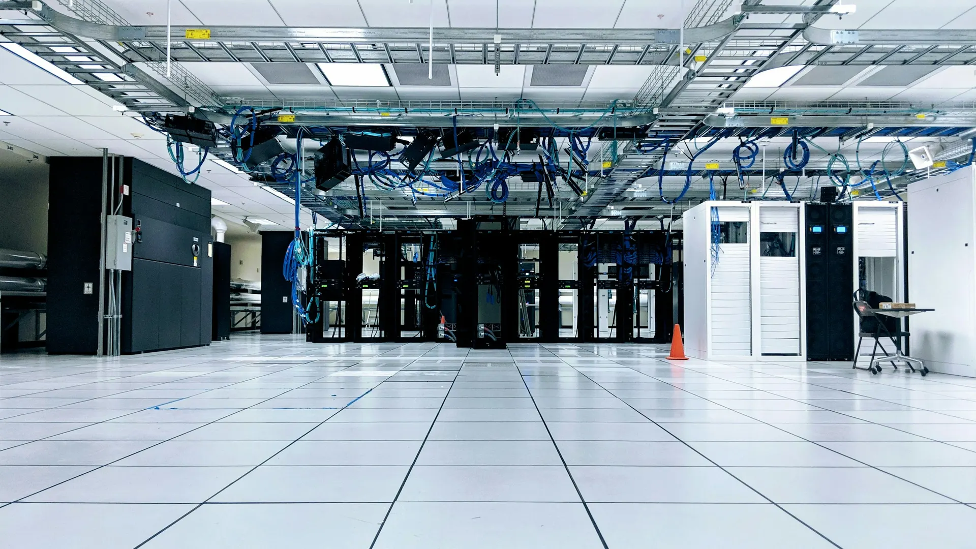 Rows of server racks inside a brightly lit data center.